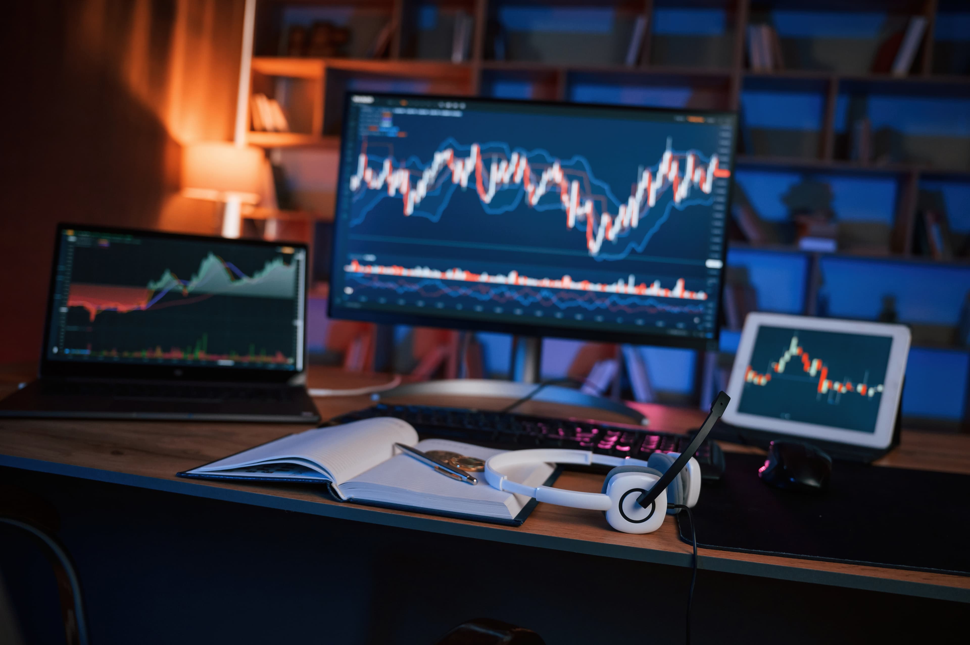Trader using a trading journal on laptop and mobile to track futures trades for prop firm evaluation performance