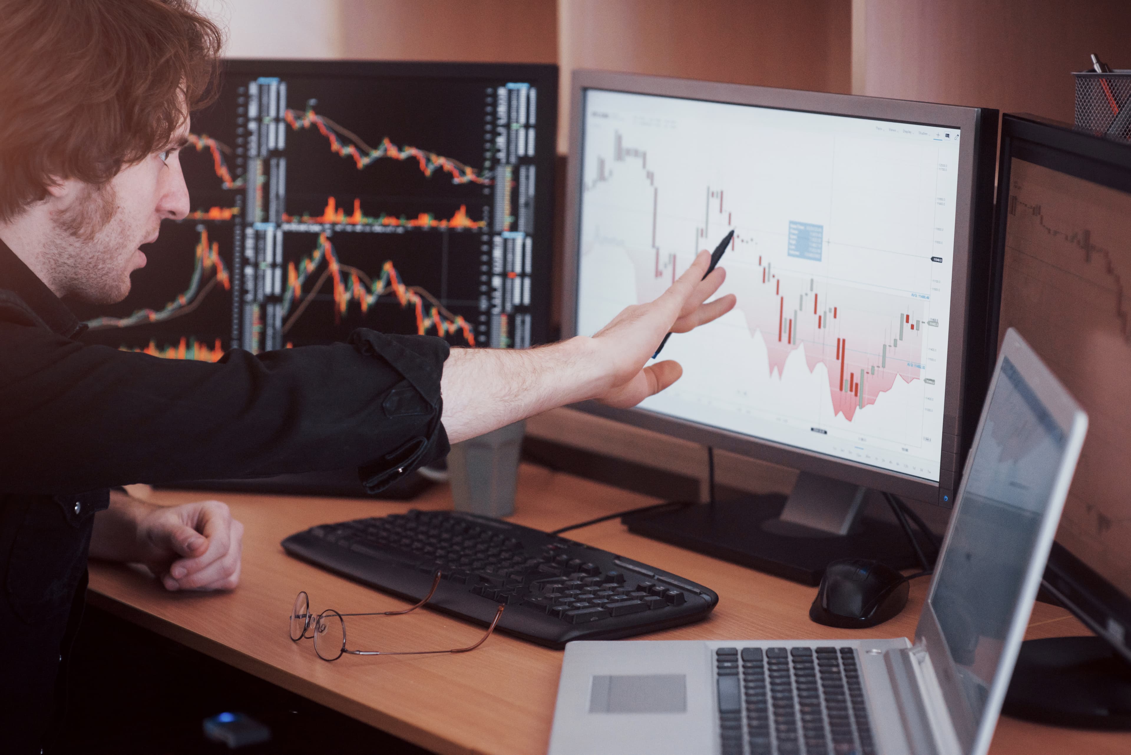 Trader señalando análisis técnico en pantalla mientras explica qué es un trading journal y cómo usarlo en fondeo