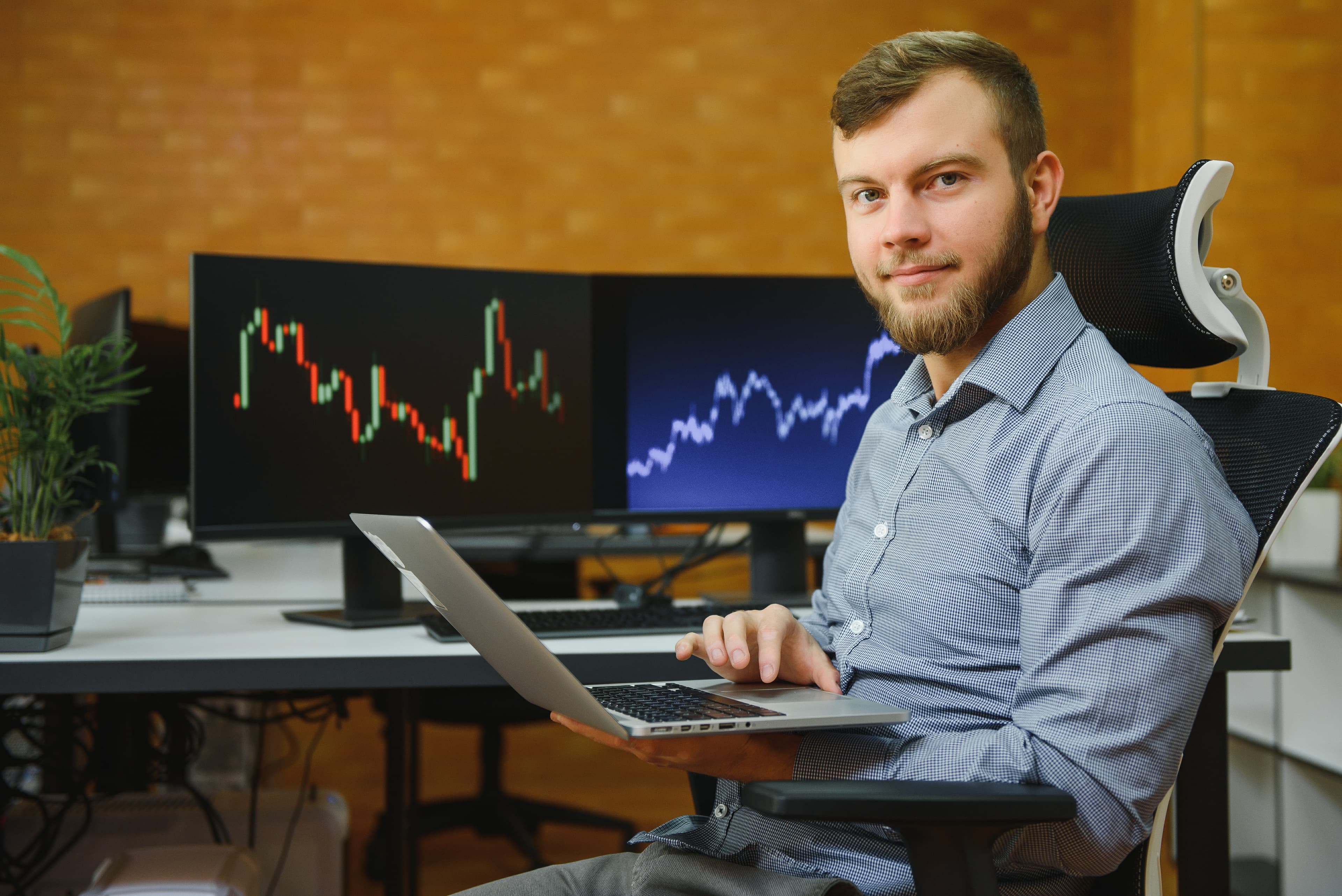 Trader at dual monitor office setup tracking FTMO evaluation metrics — consistency score, drawdown and profit factor
