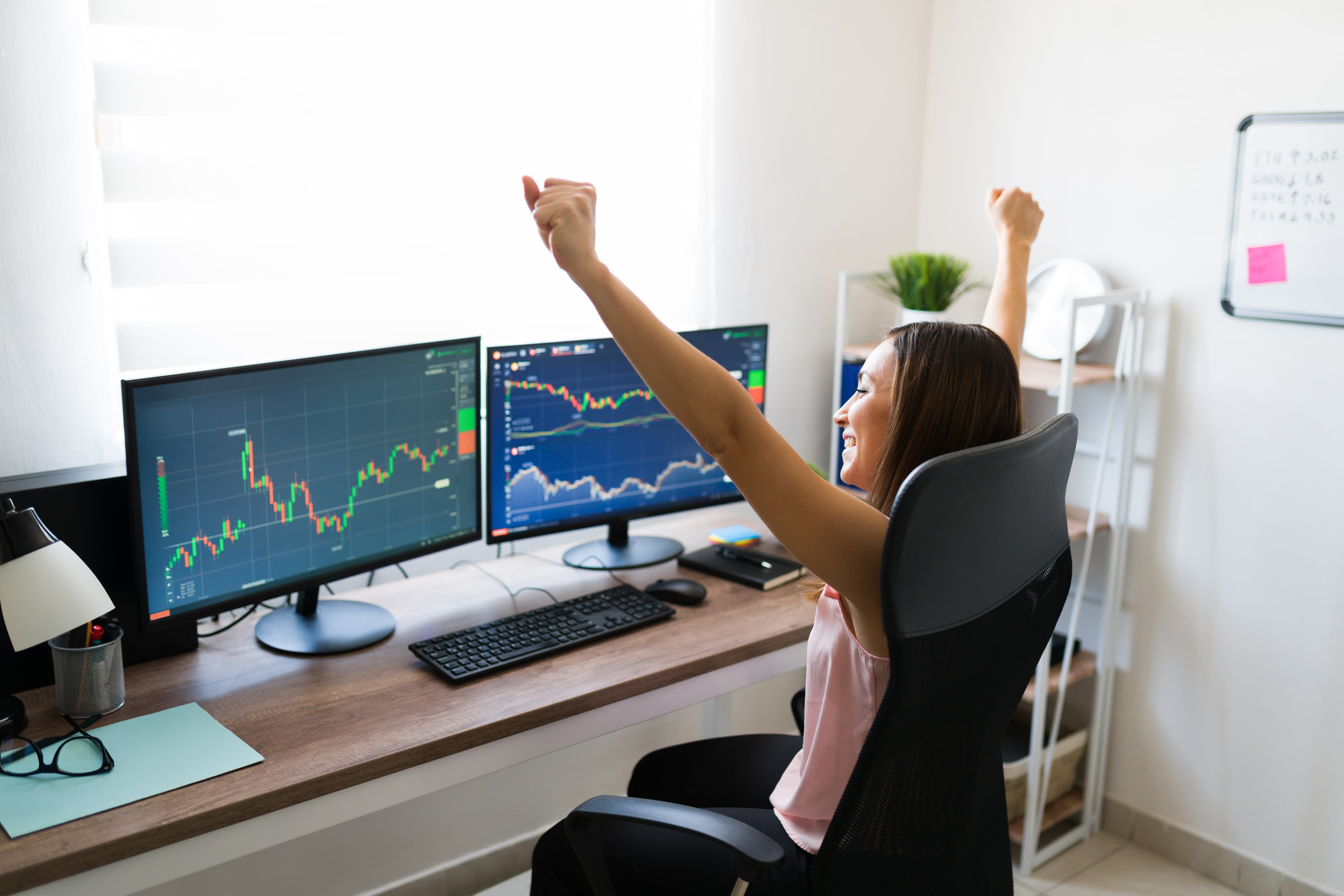 Trader celebrando con laptop haber pasado la evaluación Apex Trader Funding usando journal de trading con IA